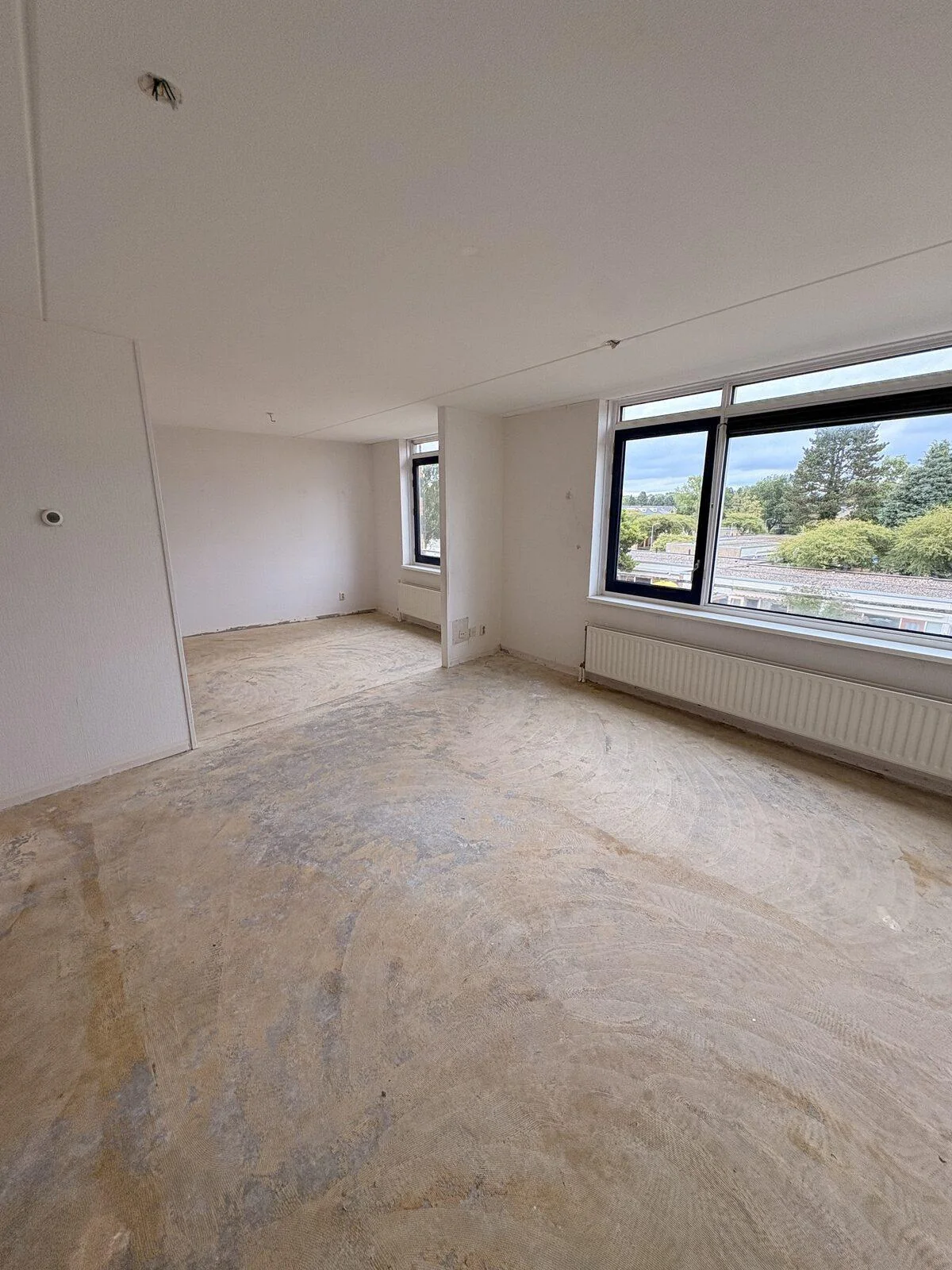Opgeleverde woonkamer in appartement in Hilversum na de woningontruiming