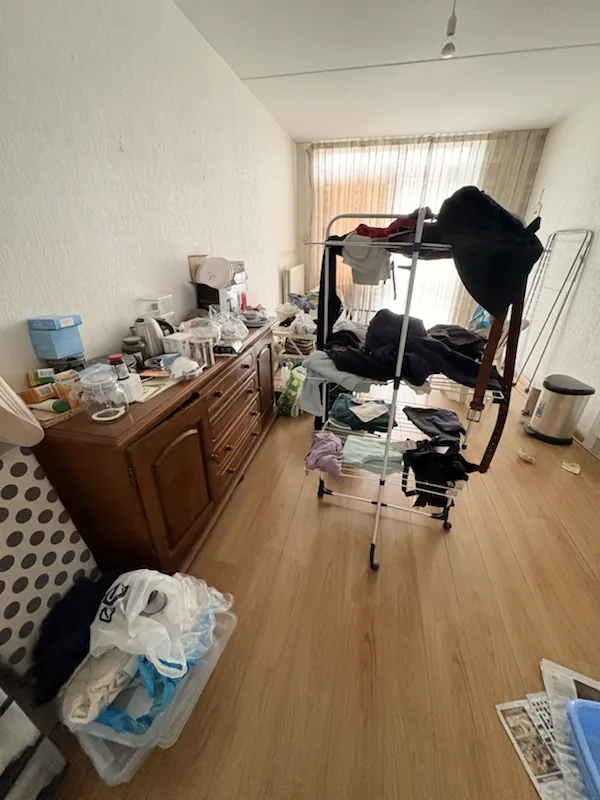 Woonkamer tijdens de voorinspectie met keuken op de achtergrond